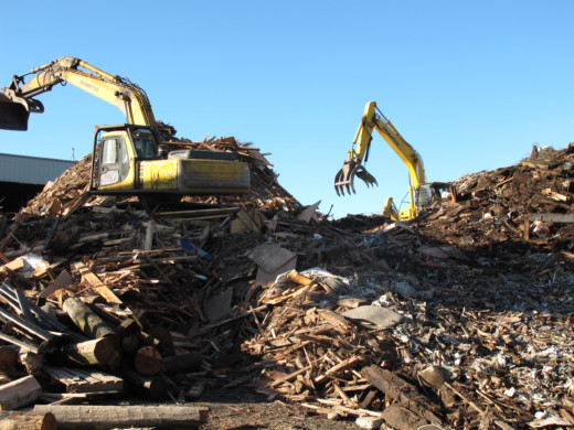Machinery at work on a mountain of debris. Urban Wood Waste Recyclers New West location.